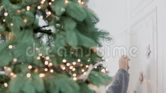微笑的女人在客厅的圣诞树附近拥抱女孩视频的预览图
