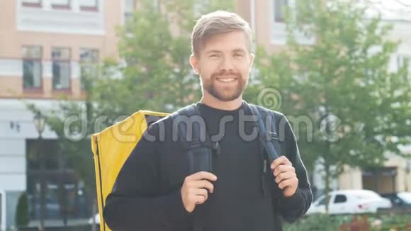 带着一个黄色袋子的快递员竖起大拇指带着背包的长胡子的家伙做了个手势微笑着派递服务视频的预览图