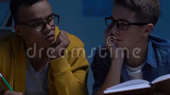 两个疲惫的男青少年在深夜学习准备大学入学考试视频的预览图