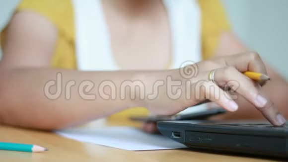 女人的手打字笔记本电脑用铅笔写在纸上隐喻在线和商业营销概念视频的预览图