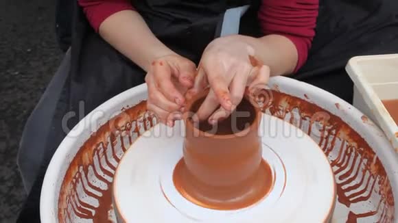 女孩的手在陶工的车轮上制作陶土视频的预览图