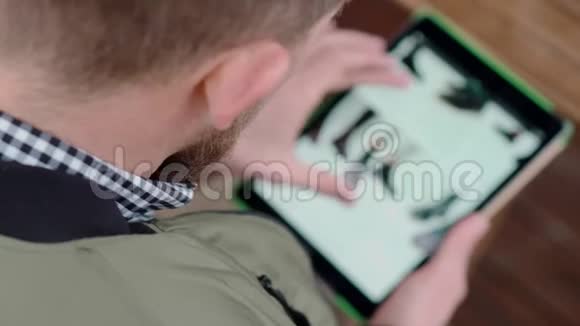 男人正在通过平板电脑查看网上鞋店的网站通过肩膀查看视频的预览图