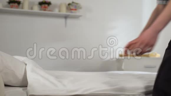家庭主妇把花放在床单上软清洁床单的概念洗涤剂视频的预览图