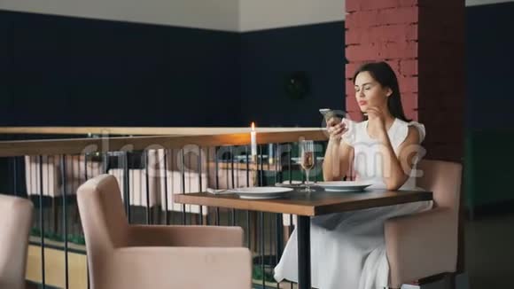 穿着白衣服的漂亮女孩在餐馆里等着她的男朋友然后叫他生气地和他说话视频的预览图