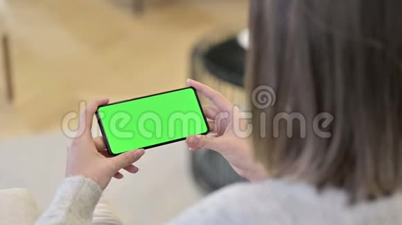 女子观看影片Chroma键屏幕智能手机视频的预览图