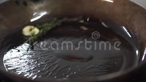 将香草大蒜和橄榄油放在煎锅上厨师添加排骨烹调现代肉类食品视频的预览图