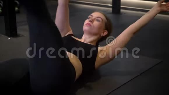 年轻体育女运动员交叉腿和手举的特写镜头集中和激励在健身房视频的预览图