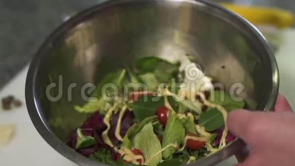 厨师手拿着大铝碗与沙拉浇西红柿菠菜和罗勒与接近厨师视频的预览图