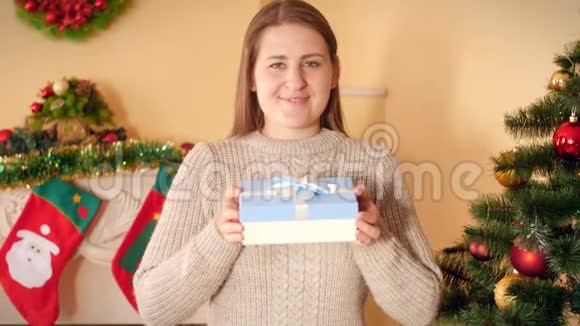 4k视频快乐微笑年轻女子展示盒装圣诞礼物镜头视频的预览图