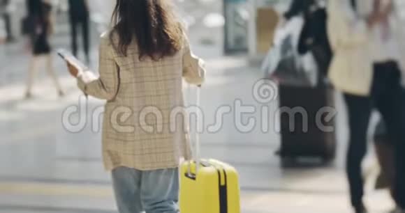 自信的热辣女孩走在机场候机楼旁用手机开心地对短信微笑视频的预览图