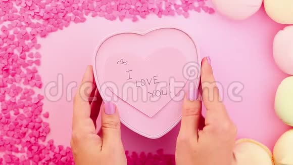 女人的手在移动一个像心盒的礼物我爱你在贴纸上签名视频的预览图