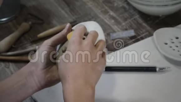 女人用湿海绵擦拭粘土制品视频的预览图