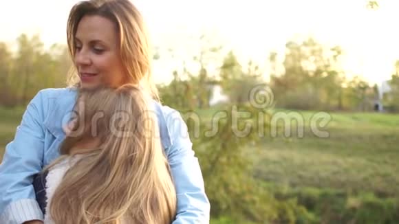 少女在秋天的城市公园拥抱她美丽的年轻母亲母亲和女儿母亲日视频的预览图