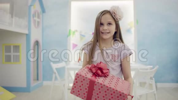 快乐的小女孩正拿着一个大礼盒在镜头前视频的预览图