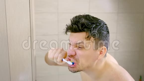 卫生间密集清洁牙齿的瘦小青年画像侧视视频的预览图