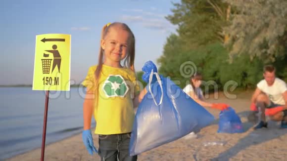 停止塑料幸福的志愿者女孩戴着橡胶手套在背景上的指针标志附近有一个垃圾袋视频的预览图