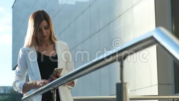 漂亮的商务女士正在智能手机上阅读一条信息视频的预览图