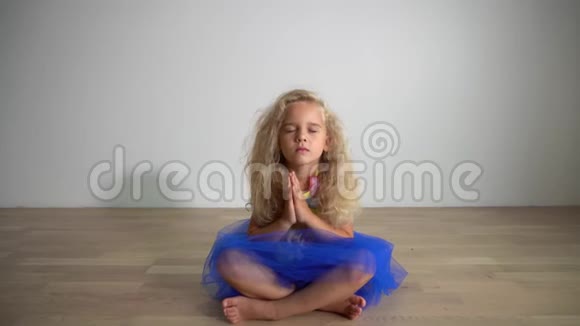 漂亮的女孩坐在地板上在家放松瑜伽概念万向节运动视频的预览图