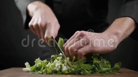 在黑色背景的木桌上为沙拉切下很多绿色生菜视频的预览图