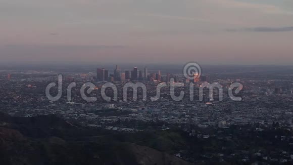 空中在美丽的日落灯光下令人叹为观止的好莱坞山和洛杉矶城市景观视频的预览图
