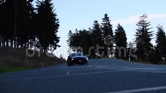 黑色福特野马汽车在山上行驶森林路有阳光路肌肉车视频的预览图