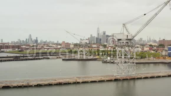 背景背景和河流在与纽约市天际线的码头工业起重机之间飞行视频的预览图