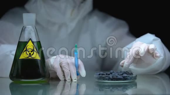 带注射器和蓝莓的生物学家桌上有生物危害液体的烧瓶视频的预览图
