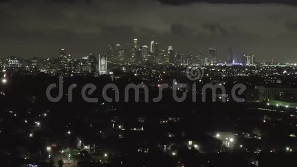 空中在黑暗的好莱坞洛杉矶上空夜幕降临乌云笼罩市中心和城市灯光视频的预览图
