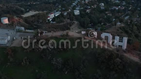 空中令人叹为观止的倾斜在好莱坞标志信背面揭示洛杉矶城市景观在美丽的日落视频的预览图