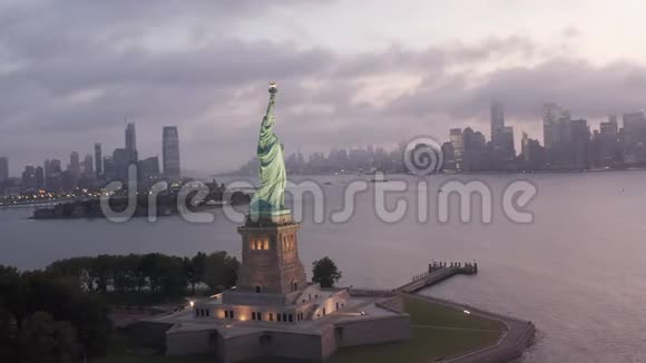 光环自由女神像在清晨的灯光下闪耀背景是多雾的纽约市天际线视频的预览图