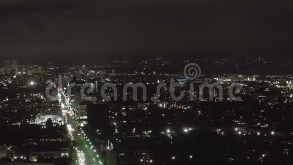 星光在黑暗的好莱坞洛杉矶在威尔郡大道上的夜景在市中心和城市灯光下有云视频的预览图