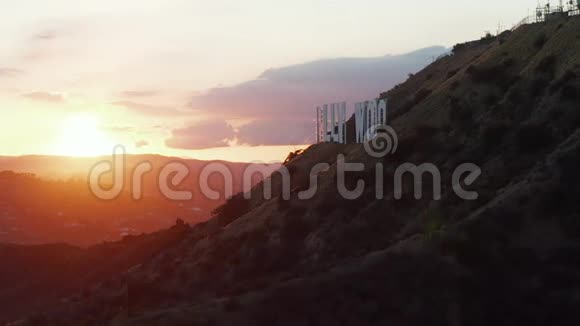 在美丽的日落黄金时间灯光下的好莱坞山和洛杉矶山边的好莱坞标志上的风景视频的预览图