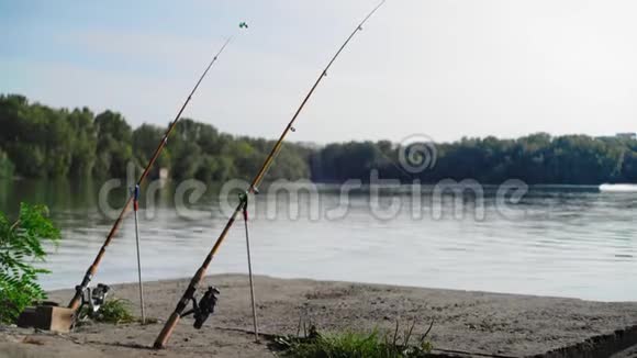 钓鱼竿矗立在河底的岸边视频的预览图