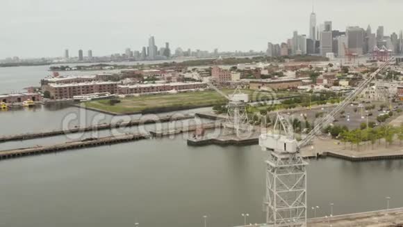 建筑在背景和河流中与纽约市天际线的码头旋转工业起重机视频的预览图