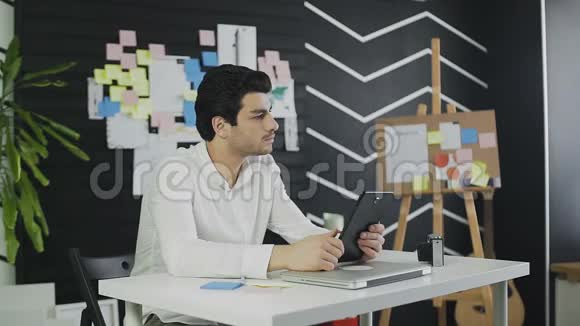 商务人员在办公室中使用带有图形数据文档的数字平板电脑视频的预览图