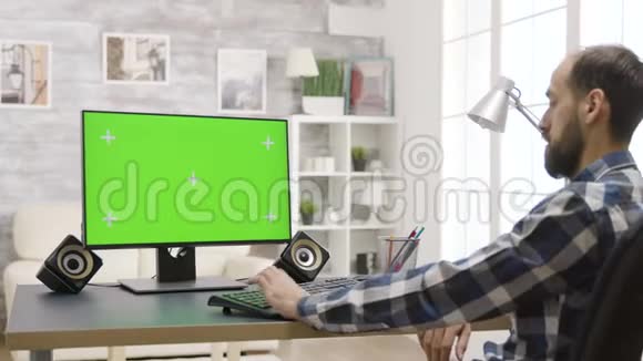 在明亮的房间里工作绿色屏幕PC的人视频的预览图