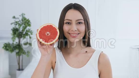 特写一个英俊的白种人女人摆着半个葡萄柚视频的预览图