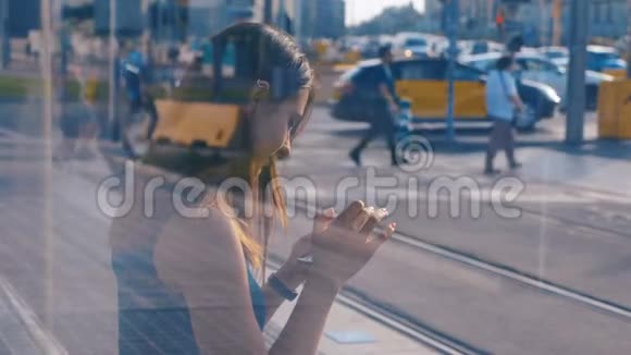 坐在公共汽车或地铁车站的年轻魅力女人的双重曝光女孩用她的手机打字视频的预览图