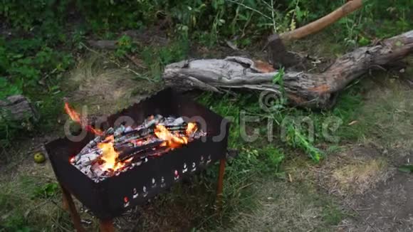 斧头背景下的烤架里燃烧着火焰视频的预览图