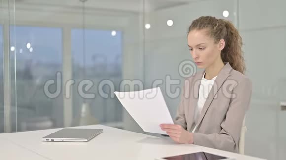 勤劳的女青年在办公室阅读文件视频的预览图