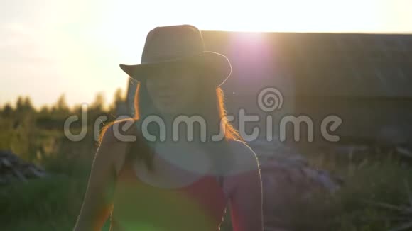 夏日日落时戴牛仔帽的白种人年轻美女肖像视频的预览图