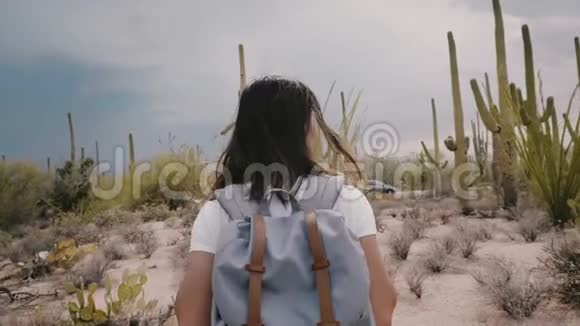 慢镜头跟随年轻快乐的旅游妇女背包走在炎热的风暴仙人掌沙漠在亚利桑那州视频的预览图