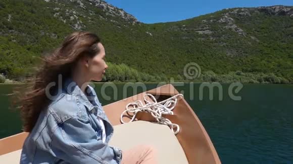 年轻女子坐在摩托艇上享受阳光明媚的日子视频的预览图