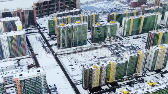 冬季城市景观空中有新的住宅建筑和被雪覆盖的地面动作鸟瞰景色视频的预览图