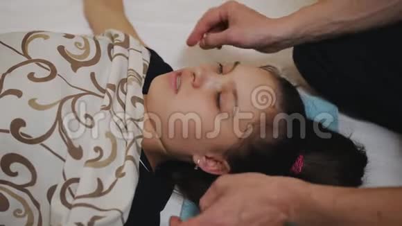 按摩治疗师在她的面部肌肉耳朵和颈部工作视频的预览图
