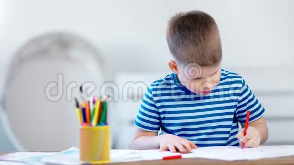 热心的小男孩用彩色铅笔在教室里用中针写纸视频的预览图