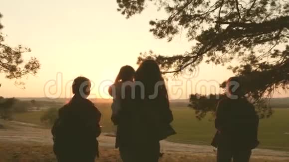 女人旅行穿过森林欣赏日落时的风景徒步旅行者女孩游客们欢欣鼓舞举起双手视频的预览图