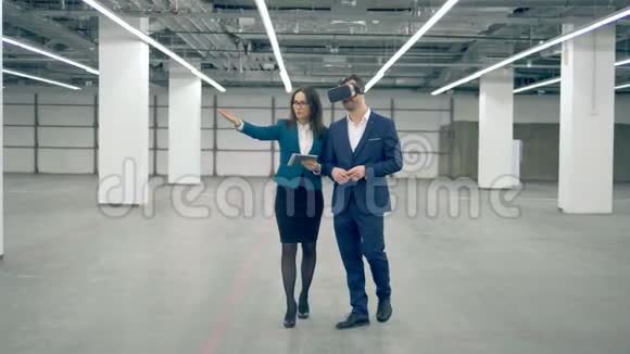 一个男人戴着VR眼镜而与一个女商人一起工作现代技术视频的预览图