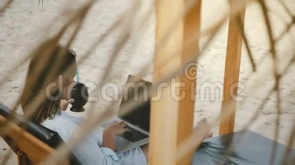 背景镜头集中成功的女性自由职业者与饮料使用笔记本电脑移动办公室在躺椅视频的预览图