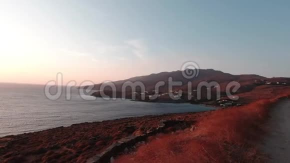 蒂诺斯岛景观海滩边有一条沙路这张照片是在魔法时刻拍摄的太阳立刻照了下来视频的预览图